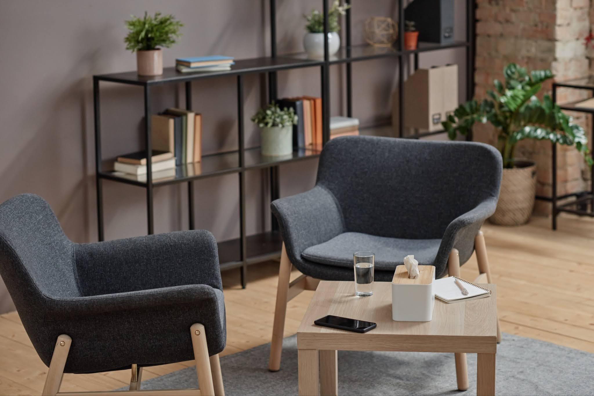 Modern cozy lounge area with two gray armchairs and a wooden coffee table