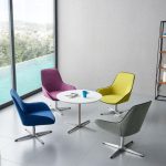 Four Vrouch H5145 swivel chairs in various colors arranged around a white table in a modern lounge