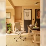 A beige upholstered Senator Qdos office chair with a chrome base, shown at a desk in a warm, wood-paneled home office