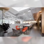 Orange and grey Carmel lounge chairs shown in a modern office background