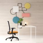 The orange Surface mid-back chair at a white desk, with a modern office background